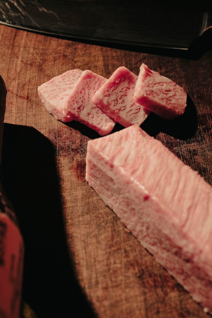 High-quality marbled Wagyu beef slices on a wooden cutting board, perfect for gourmet cooking.