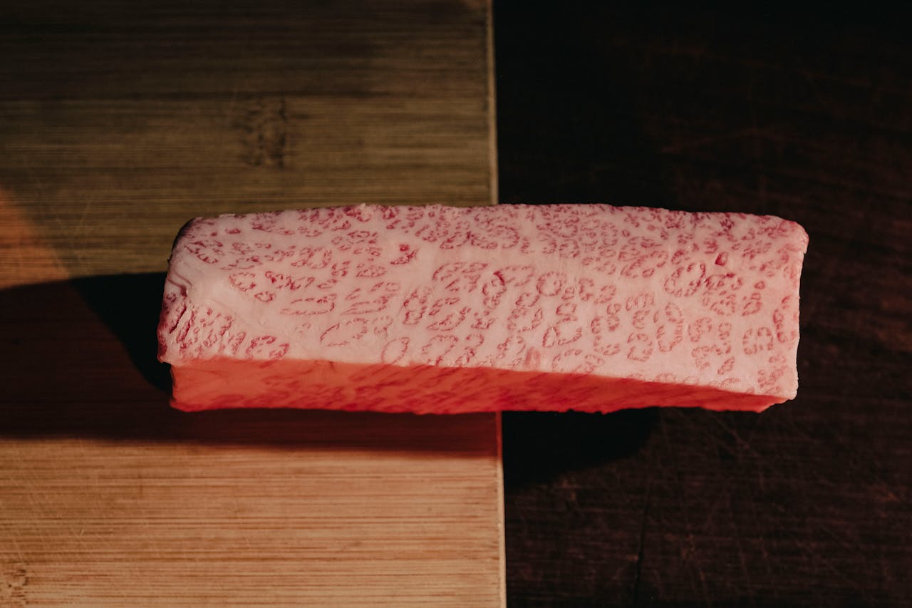Close-up of premium marbled meat on a cutting board, showcasing texture and quality.