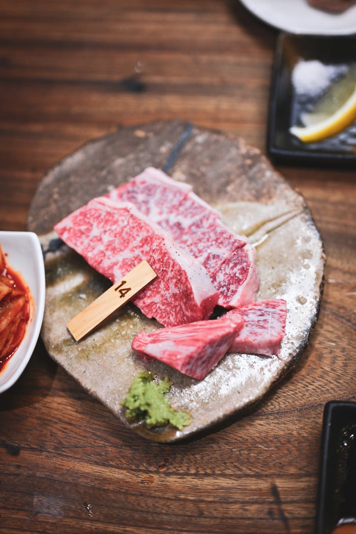 High-quality raw Wagyu beef slices arranged on a rustic ceramic plate in Kyoto, Japan.