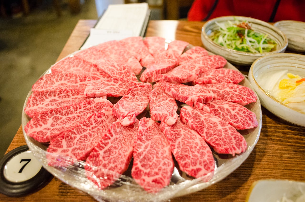 Close-up of beautifully marbled premium Wagyu beef slices arranged on a plate for serving.