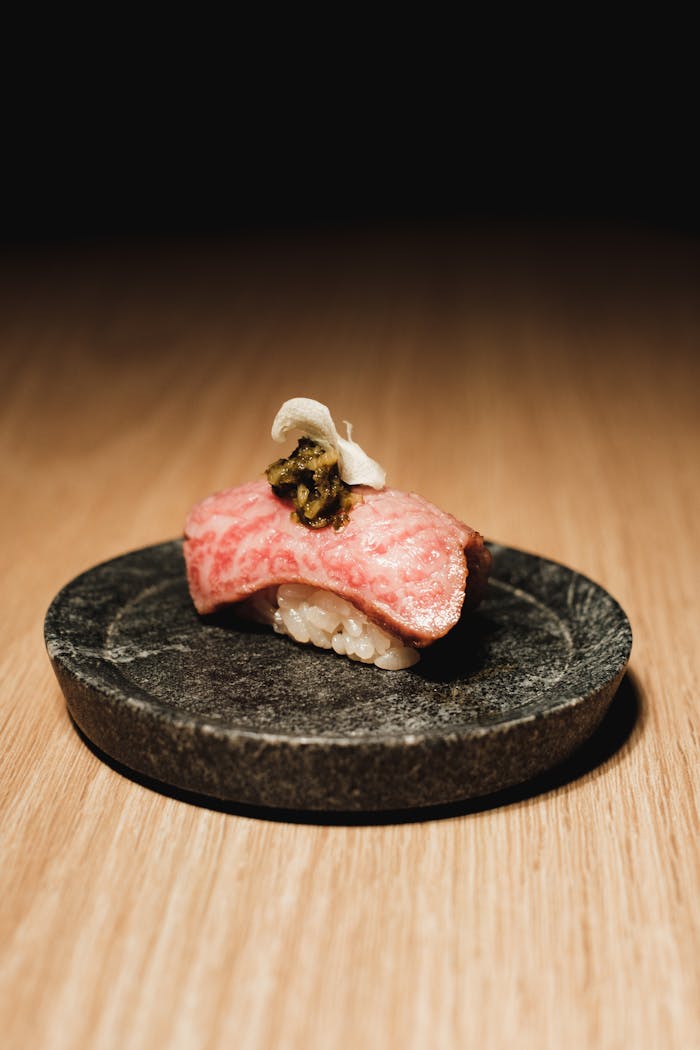 Close-up of gourmet nigiri sushi with wagyu beef, beautifully presented on a stone plate, perfect for culinary lovers.